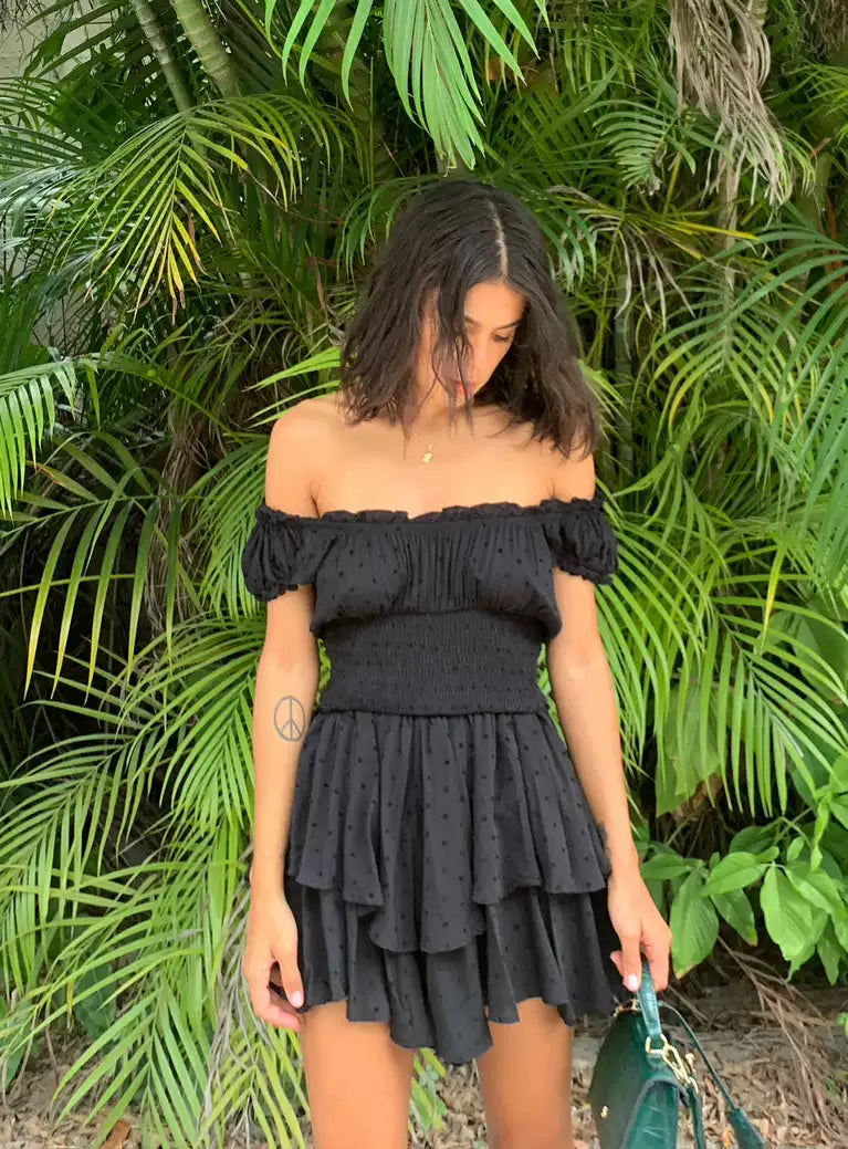 Princess Polly, a spicy girl with ruffled edges and off the shoulder, is wearing the same black waist cinching elastic slimming dress