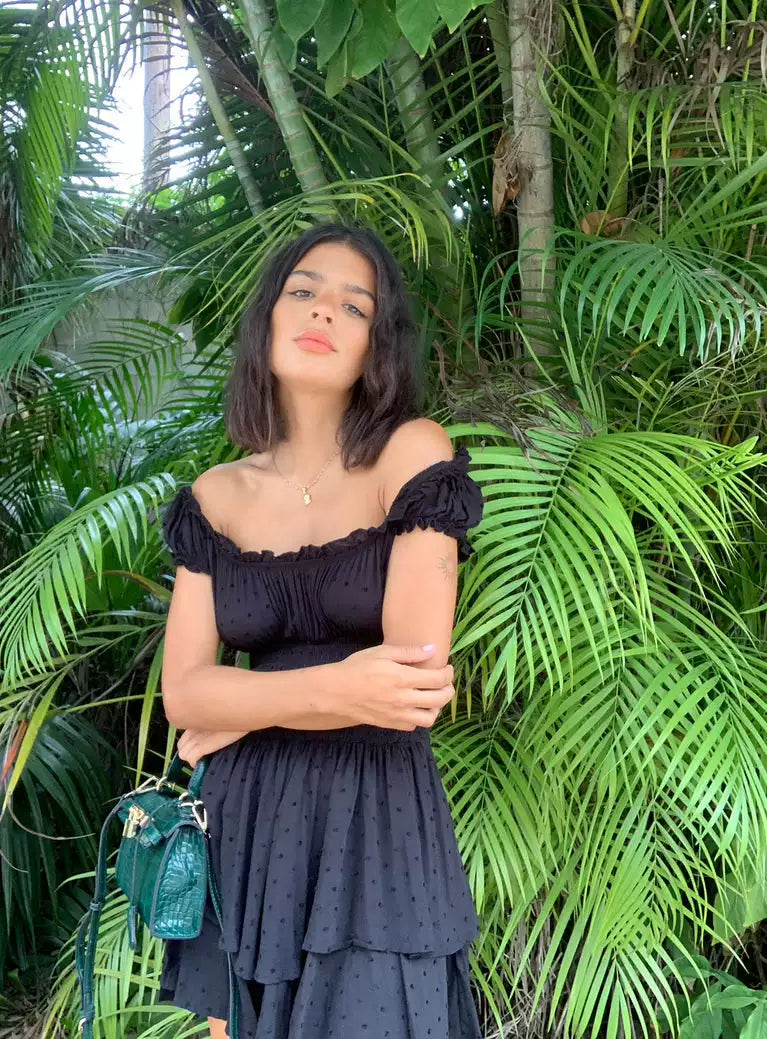 Princess Polly, a spicy girl with ruffled edges and off the shoulder, is wearing the same black waist cinching elastic slimming dress