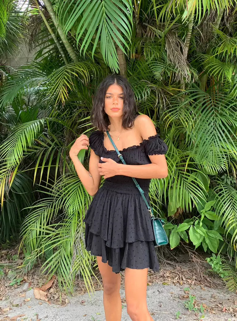 Princess Polly, a spicy girl with ruffled edges and off the shoulder, is wearing the same black waist cinching elastic slimming dress